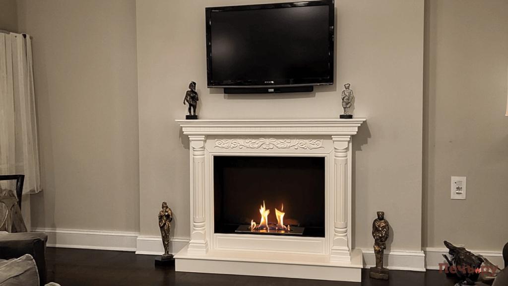 Биокамин Виктория Gen4 биокамин стоит в гостиной у стены над ним висит телевизор и стоят статуэтки 3101957705 (1) (1).jpg